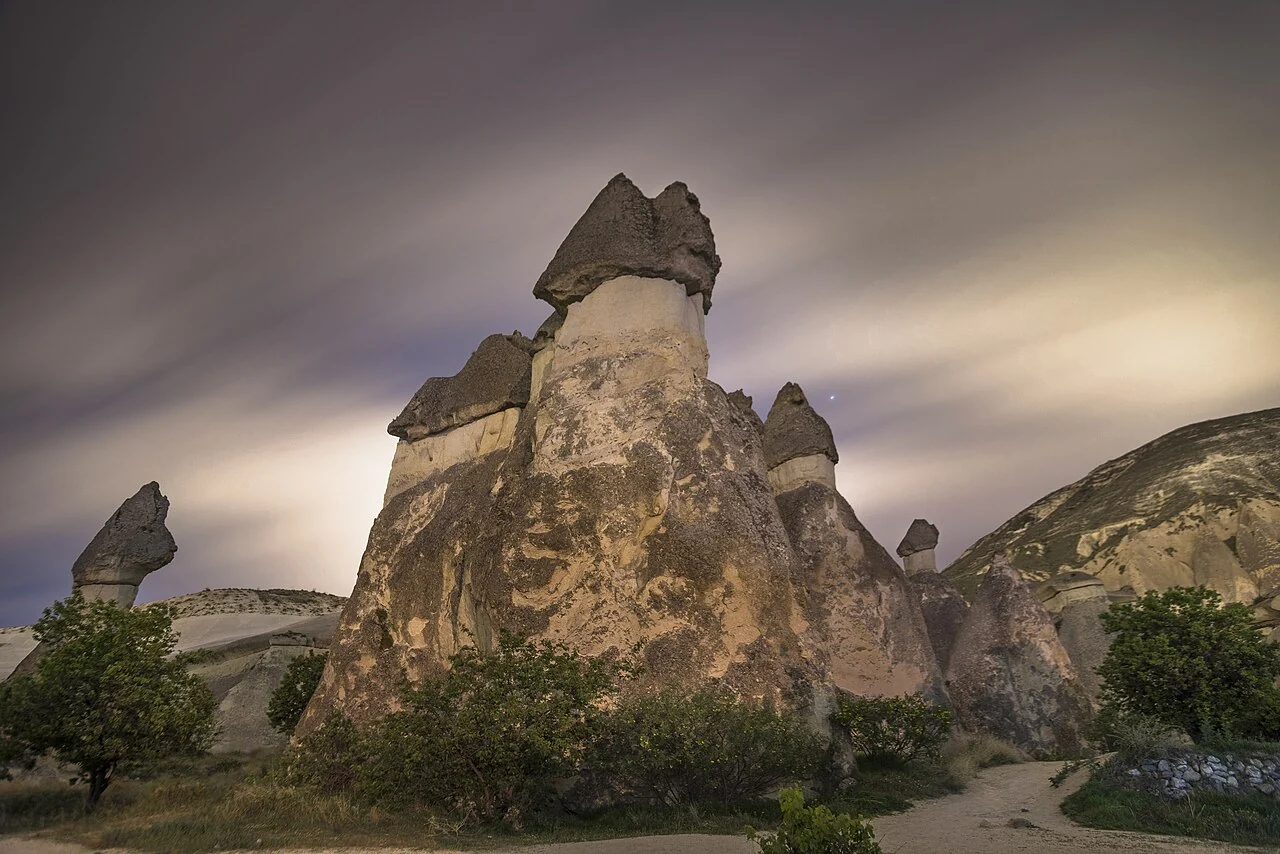 Tall capped fairy-chimney formations at Paşabağ Monks Valley beneath a cloudy sky.