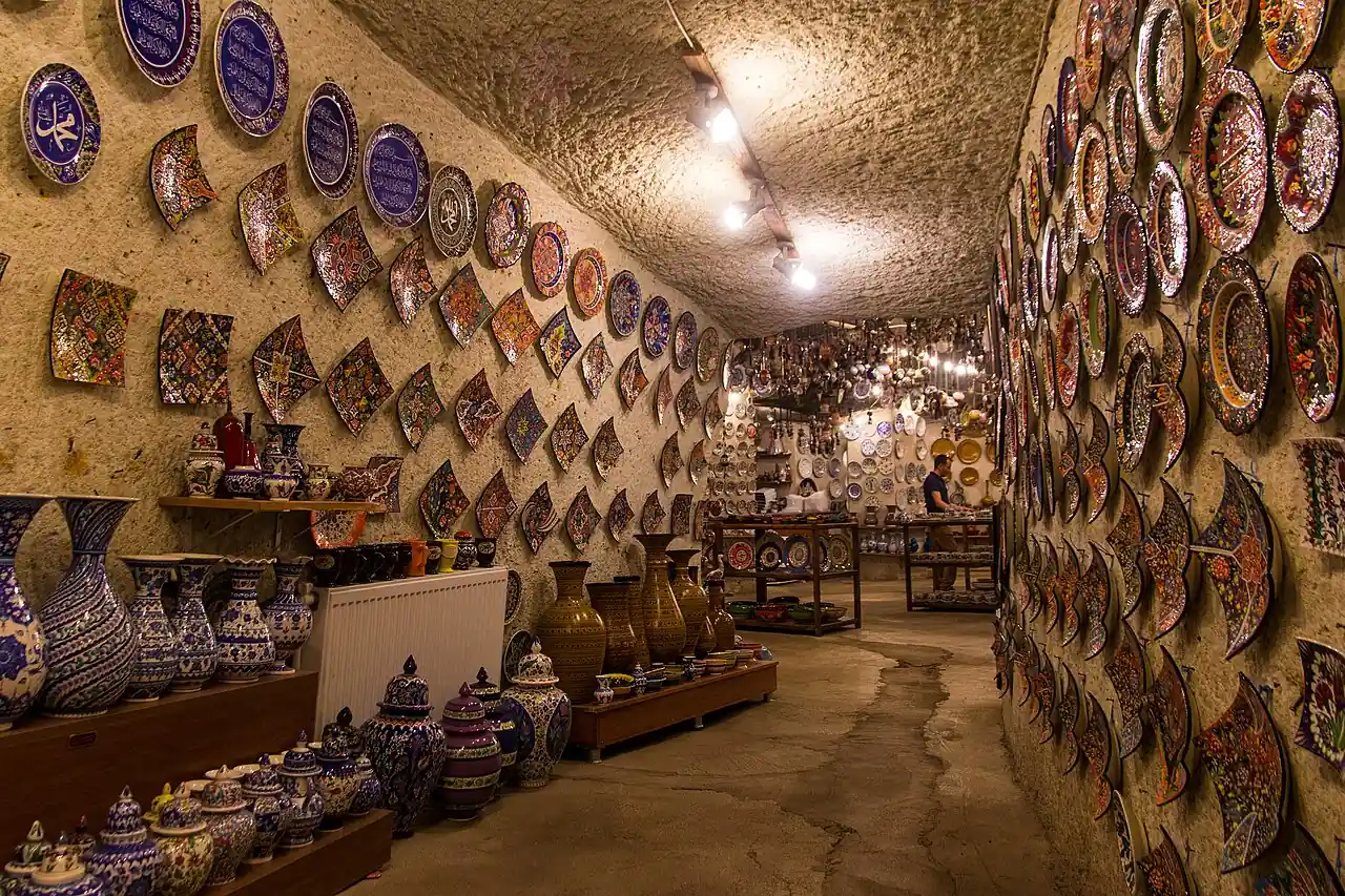 Decorative ceramic plates and vessels lining a stone-walled pottery workshop in Avanos, Cappadocia.