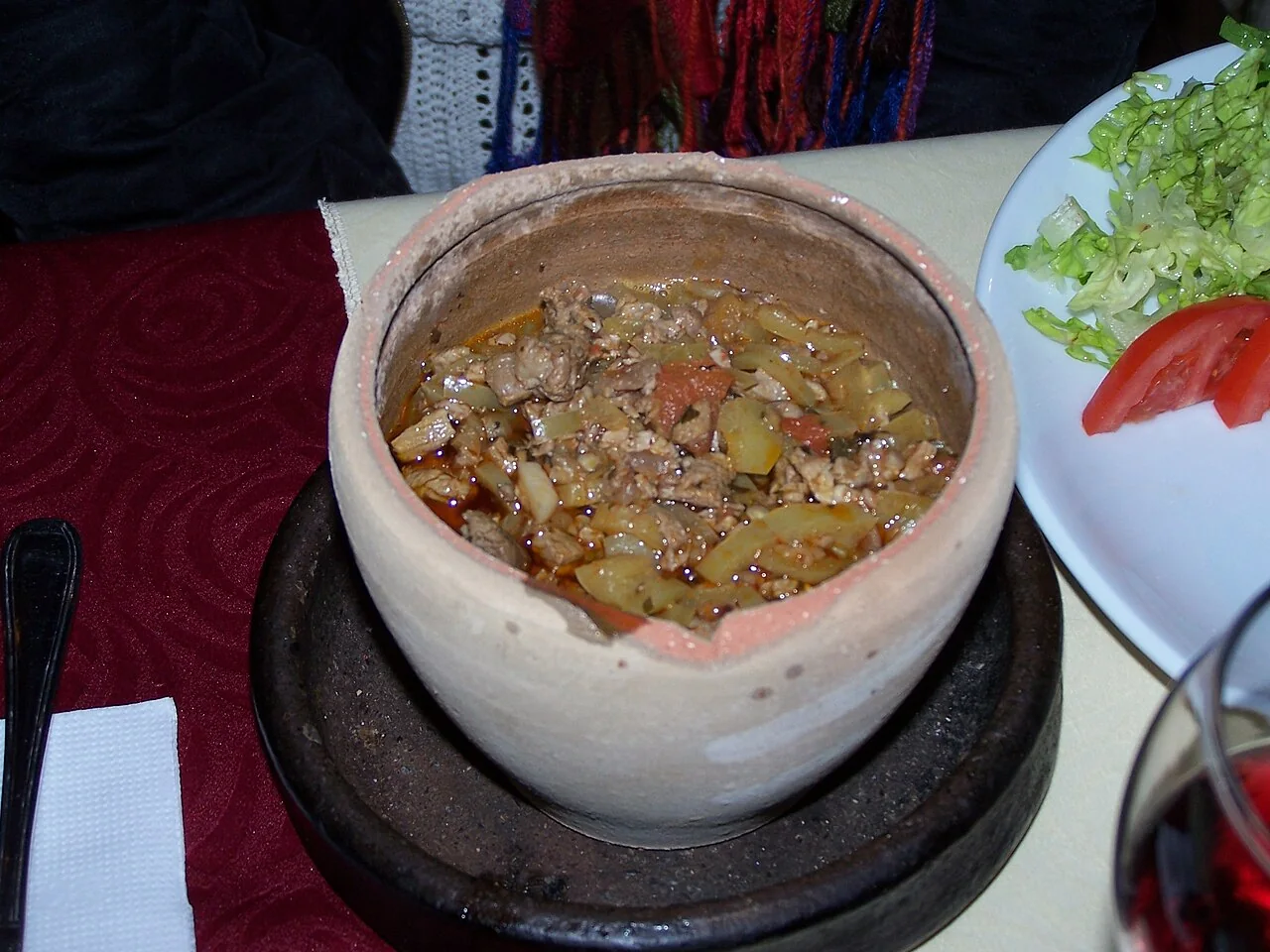 Testi kebab served in an opened clay pot with salad in Göreme, Cappadocia.